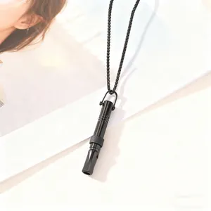 Detailed close-up view of a sleek black mindful breathing whistle necklace for anxiety relief.