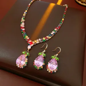 Close-up of luxury vintage jewelry set with pink pear-shaped crystals and colorful gems