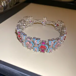 Vista detallada de pulsera vintage con circonitas ovales rosas y rojas y detalles turquesas.