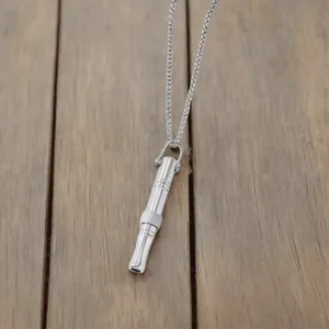 Detailed view of a silver titanium steel whistle pendant necklace for anxiety relief