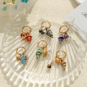 Detailed view of assorted nautical seashell hoop earrings on a decorative shell tray