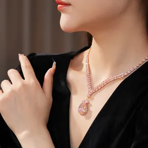 Detailed macro view of pear-shaped pink crystal necklace with gold-toned plating.