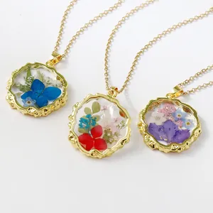Elegant resin necklace with real preserved flowers in textured gold bezel