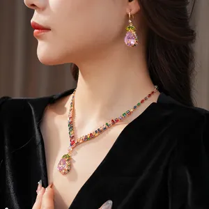 Close-up detail of luxurious pink water-drop gemstone necklace and matching earrings