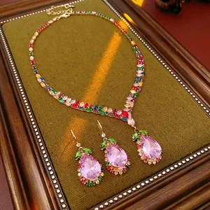 Detail of a luxury court style jewelry set with pink teardrop crystals and gold finish.