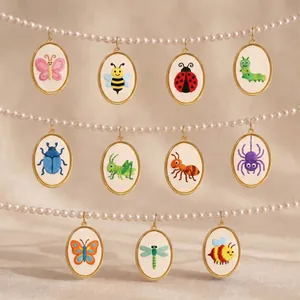 Detailed view of multiple oval embroidery pendants featuring colorful cartoon insects.