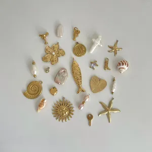 Variété de breloques en acier doré incluant soleil, cœur et coquillage pour bijoux DIY.