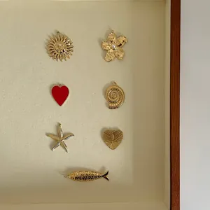 Collection de breloques dorées en acier inoxydable pour la création de bijoux DIY.