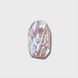 Gros plan d'un pendentif en coquillage rose irisé irrégulier pour la création de bijoux DIY.