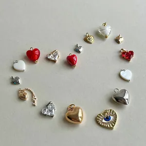 Detailed view of various colorful stainless steel heart and evil eye charms for DIY jewelry