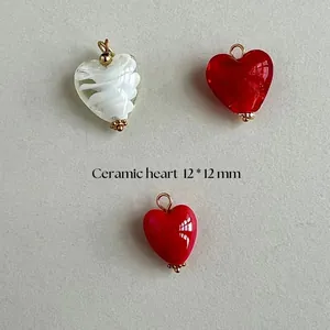 Detail view of 12x12mm red and white ceramic heart pendants for DIY jewelry making