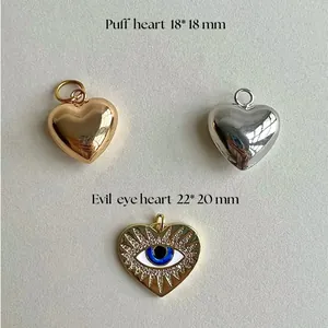 Close-up of stainless steel puff hearts and evil eye pendant with specific measurements