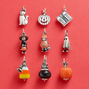 Collection de breloques DIY d'Halloween en acier titane sur un fond rouge vif éclatant