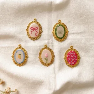 Vintage style stainless steel oval pendants with floral and bow designs for DIY jewelry.