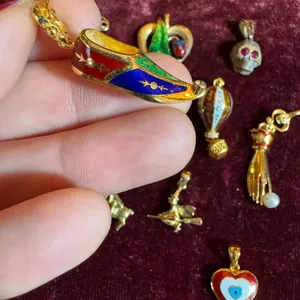 Gros plan de divers pendentifs de bijoux DIY vintage, y compris des breloques en émail.