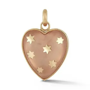 Gros plan d'un pendentif cœur pêche élégant avec étoiles dorées incrustées et finition 18k