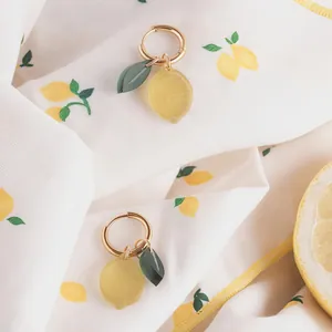 Detail view of handmade lemon fruit charms on stainless steel gold hoop earrings