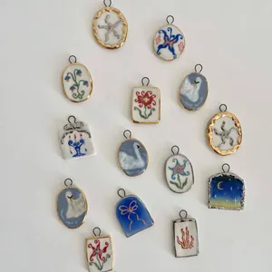 Vue détaillée de divers pendentifs imprimés avec des motifs de cygne, fleur et nœud pour bijoux DIY