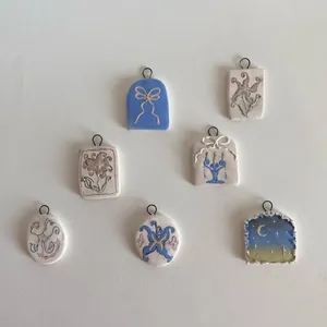 Vue détaillée de pendentifs en céramique faits main aux motifs floraux et nœuds pour DIY