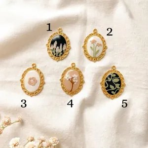 Collection of five vintage oval floral pendants with ornate gold borders for DIY jewelry making