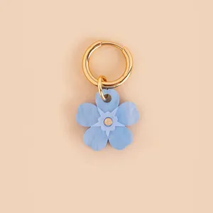 Detailed macro view of a blue flower pendant featuring a polished gold stainless steel hoop.