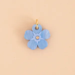 Detail of a blue marble flower pendant charm with a golden jump ring for DIY jewelry making.