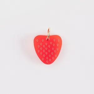 Detailed macro view of a red frosted strawberry pendant with gold ring for DIY jewelry