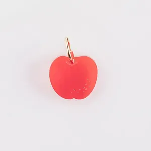 Macro view of a red translucent apple-shaped stainless steel pendant DIY jewelry part