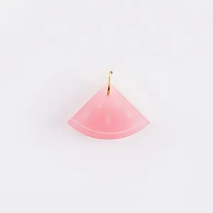 Detailed view of a pink translucent watermelon slice pendant with a gold ring