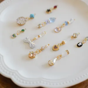 Collection of diverse fashion charms including bow, heart, and gemstone pendants on a plate.