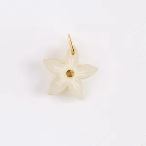 Elegant white flower pendant detail with gold-plated stainless steel center and bail.