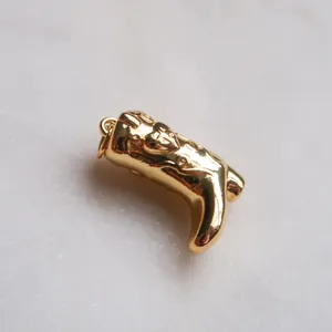 Detailaufnahme eines goldenen Cowboy-Stiefel-Anhängers mit Herzmuster-Gravur