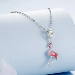 Vue détaillée d'un pendentif flamant rose avec cristaux rouges sur une chaîne argentée.