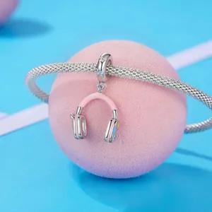 Gros plan d'un pendentif casque en émail rose sur un bracelet en argent texturé