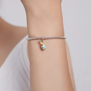Détail d'un bracelet en acier inoxydable avec breloque bouteille de champagne.