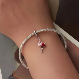 Gros plan détaillé d'un pendentif flamant rose sur un bracelet en maille argentée