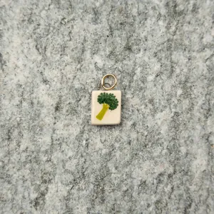 Macro view of a square broccoli pendant with a gold ring on a stone background