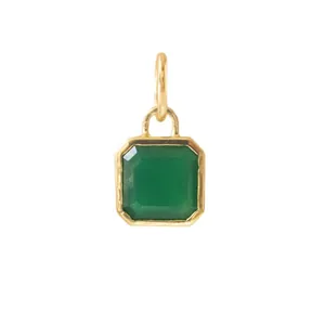 Macro detail of vintage 18K gold plated stainless steel pendant with emerald cut green stone