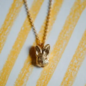 Detailed macro view of a 18K gold-plated stainless steel textured rabbit head necklace