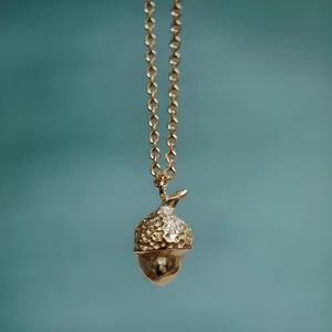 Detail view of a 18K gold plated stainless steel acorn pendant necklace for women