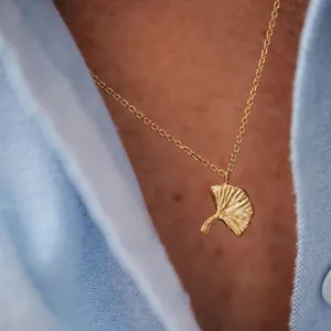 Close-up detail of a delicate 18K gold plated ginkgo leaf pendant necklace for women