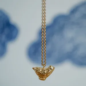 Detailed close-up showing the textured surface of an 18K gold plated maple seed pendant