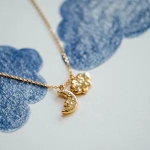 Close-up of 18K gold plated stainless steel necklace with moon and cloud pendants