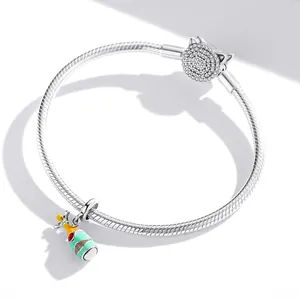 Détail d'un bracelet en maille serpent argentée avec fermoir chat et breloque champagne