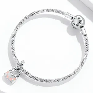 Gros plan d'un bracelet en maille argentée avec fermoir 'Forever Family' et pendentif cœur