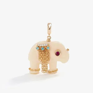 Detailed macro view of an ivory-colored elephant pendant with gold chains and crystals