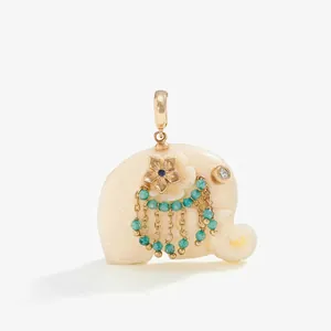 Detail view of an ornate elephant pendant with turquoise beads and gold floral accents.