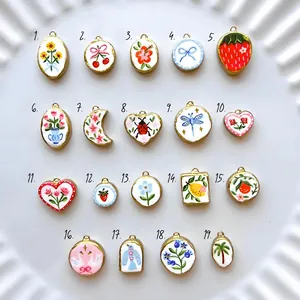 Selection of hand-painted enamel style jewelry pendants with floral and fruit motifs