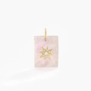 Close-up of a square pink stone pendant with a gold diamond-set star design.