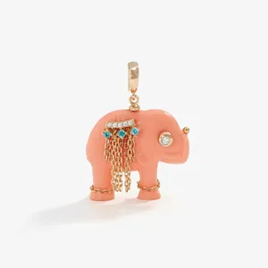 Macro detail of a pink coral elephant pendant featuring gold tassel chains and rhinestones.